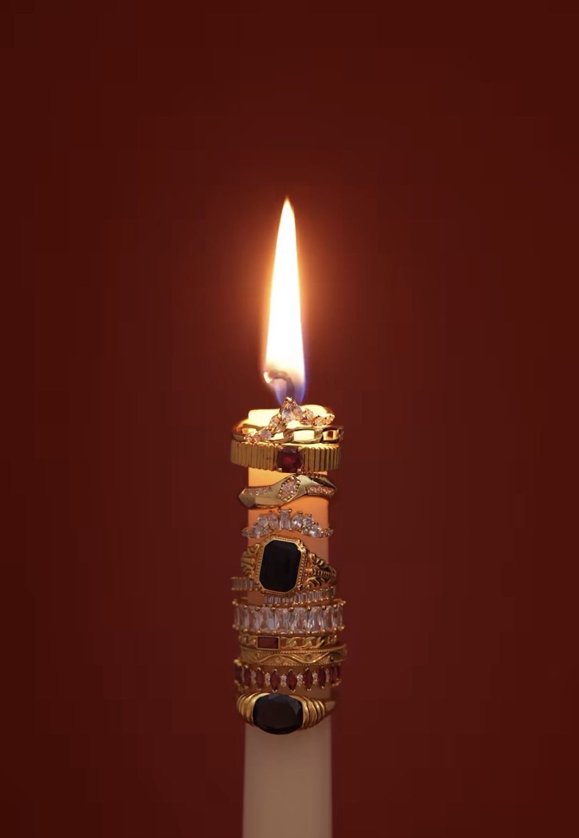 Wedding rings arranged around a glowing candle